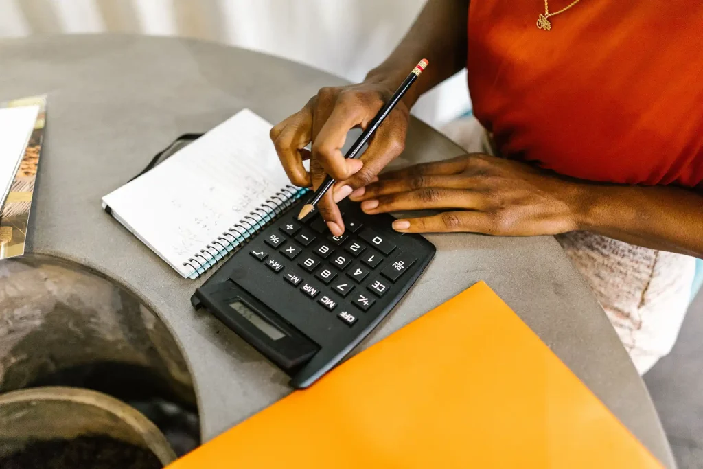 Woman uses calculator while managing finances